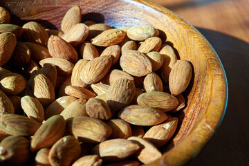 Almonds in a wooden bowl under the bright sun