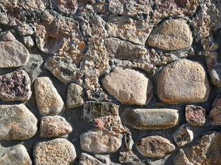 Old Wall made of different stones. Texture and background