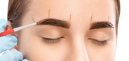Make-up artist paints eyebrows. Professional makeup and facial care.
