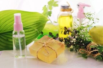 Medicinal herbs, natural soap, tincture and aromatic oil on a wooden table, the concept of spa, body care, alternative medicine, organic cosmetics