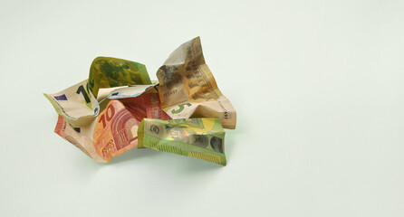 A pile of crumpled euro banknotes on a gray background. Minimalism, concept.