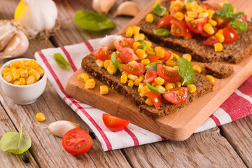 Rye bread withsweet corn, basil and tomato.