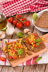 Rye bread withsweet corn, basil and tomato.