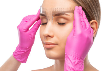 Make-up artist makes markings with white pencil for eyebrow and paints eyebrows. Professional...