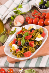 Fusilli pasta with cherry tomatoes, eggs and black olives.