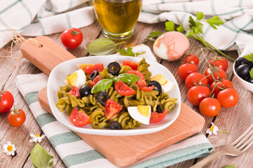 Fusilli pasta with cherry tomatoes, eggs and black olives.
