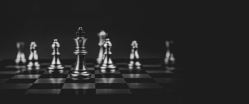 Close-up king chess standing first on chess board concepts challenge or battle fighting of business team and leadership strategy and organization risk management or team player.