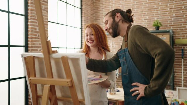 Man and woman artist couple smiling confident drawing at art studio
