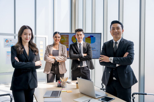 4 Asian businessmen with good looks in suits Standing with arms crossed and smiling. The concept is Finance, Marketing, Insurance, Bank Clerk. working as a team in harmony