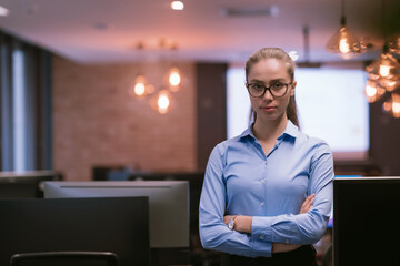 Portrait of freelancer standing in co-working space. Confident businesswoman looking at camera.