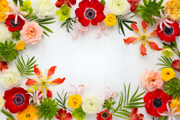 Frame flowers composition. Arrangement of anemones, roses, ranunculus, tropical flowers, succulent and leaves on light background.