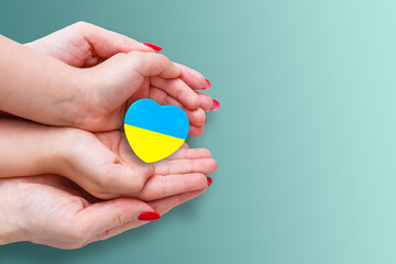 The national flag of ukraine with the coat of arms in female hands. Flat lay, copy space