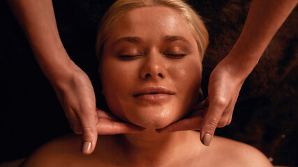 Fototapeta na wymiar Portrait of masseur doing face massage of woman