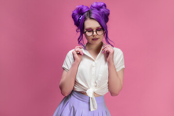 bright girl with purple hair wearing glasses portrait on pink background