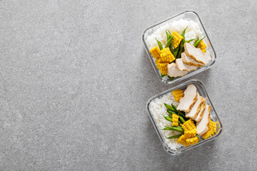 Lunch boxes with grilled chicken breast, rice, corn and green beans. Top view, flat lay