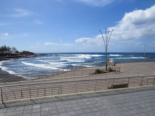 El paseo marítimo de El Puertillo, localidad del norte de la isla de Gran Canaria, España. Olas costeras en un día tranquilo y sin apenas viento.