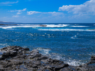 Fototapeta na wymiar Paisaje costero de la localidad de El Puertillo, Isla de Gran Canaria, España. Paisaje agreste modelado por las olas sobre las rocas volcánicas.
