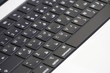 Close up of laptop keyboard with two languages Arabic and English, arabic letters