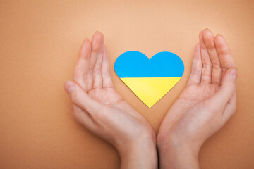 Heart with print the national flag of ukraine in female hands.
