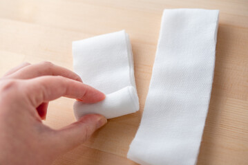 包帯を丸める手
