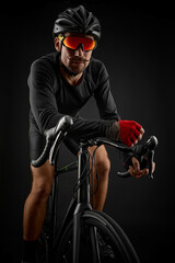 male cyclist riding road bicycle on black background