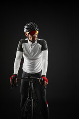 male cyclist with road bicycle on black background - obrazy, fototapety, plakaty