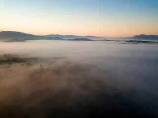 Sunrise over the fog in the Ukrainian Carpathians. Aerial drone view.