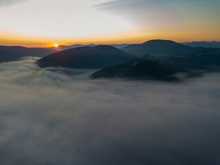Fototapeta premium Sunrise over the fog in the Ukrainian Carpathians. Aerial drone view.
