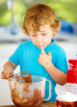 The future of the culinary arts. A little boy covered in dough and flour.