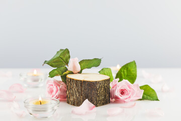 Natural product display on neutral light grey background with flowers. Wooden podium with pink roses. Concept scene stage showcase for new product, promotion sale, banner, presentation, cosmetic