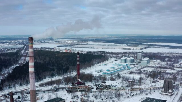 Smog smoke carbon and pollution emissions from industry smokestacks.  Pollution of the atmosphere by an industrial enterprise of the TPS station. Cloudy day in the winter. Cinematic footage