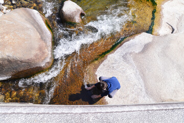 Korean children dip hands in flowing valley  water.