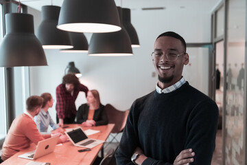Portrait of happy Afro American millennial male business owner in modern office. Businessman...