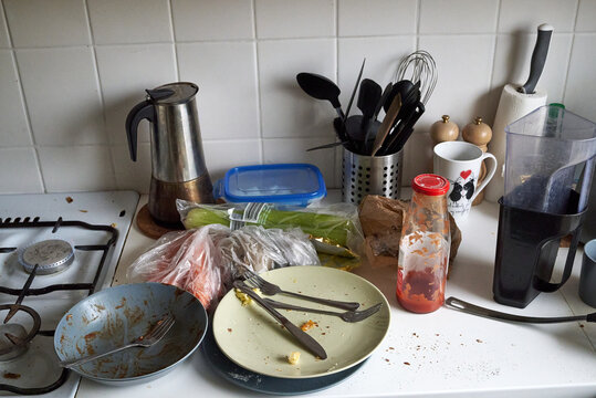 Dirty Plates, Cutlery, Kitchen Utensils After Cooking In A White Kitchen