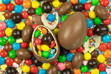 Fototapeta na wymiar Background of chocolate Easter eggs and colorful sweets, candies and shell fragments.