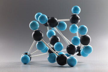 Molecular model structure, miniature on grey background, blue and black cells connected