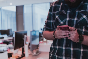  Office manager work in coworking space using smartphone analyzing online market trends, focused man worker reading financial news or browsing internet on phone. Technology concept