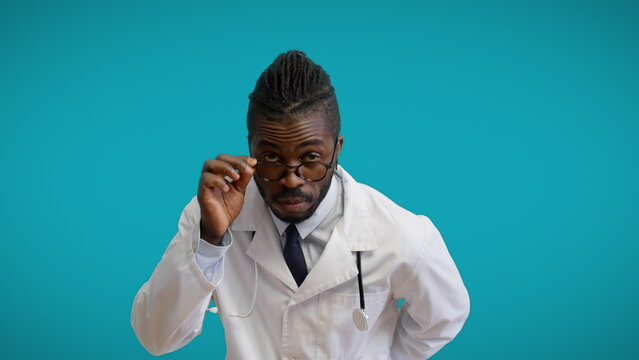 Surprised African therapist in eyeglasses looking at camera, unusual case, unknown disease - Powered by Adobe