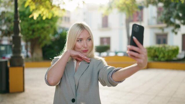 Young blonde woman executive making selfie by the smartphone at park