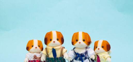 dog family on an isolated blue background. mother, father, sister and younger brother. dog character toys. copy space for Valentine's Day, Christmas Day and  family day. 