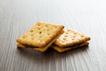 Biscuit with chocolate filling on wooden background