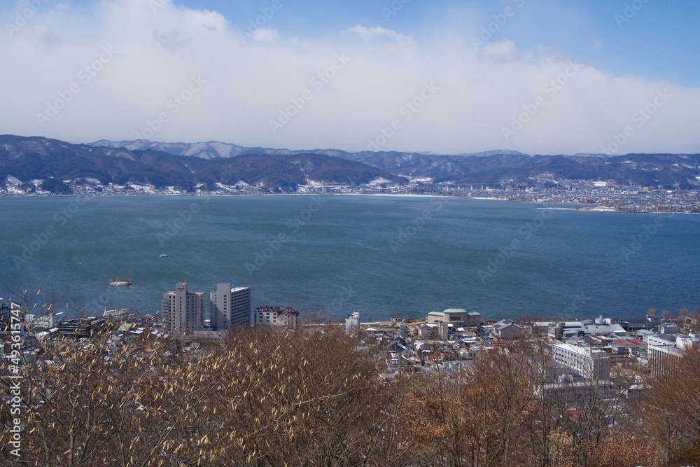 Poster The scene of Lake Suwa and snow covered mountains in Nagano.