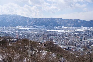 Landscape of Suwa city with snow covered mountains.