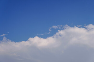 White clouds at the bottom of the image, the top of the image is a blue sky, copy space.