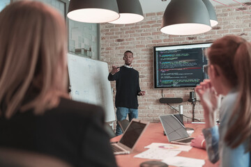 Leader give a business presentation at an office conference meeting, businessman coach mentor explains graph chart on board corporate group workshop training in boardroom. Selective focus 