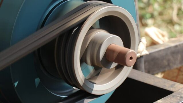 Close up view of working belt drive pulley from a diesel engine, Rotating shaft of the diesel engine with pulley