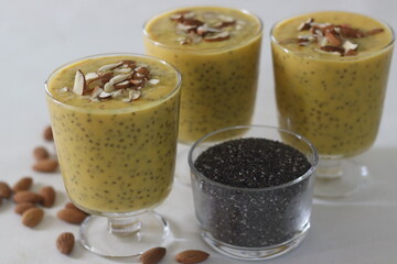 Milkshake with alphonso mango and chia seeds, garnished with sliced almonds