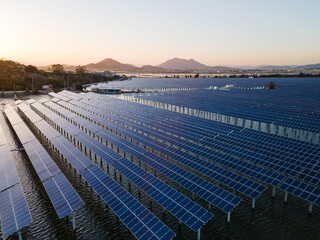 Fototapeta premium An aerial view of a solar power plant in the sea at sunset.New Energy Technology. Photovoltaic power generation. Energy Conservation and environmental protection.
