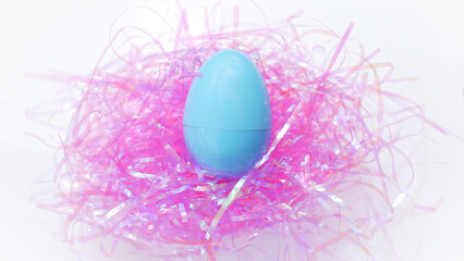 Blue easter egg on pink confetti 