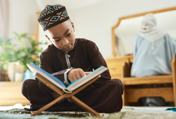 Children more than ever, need opportunities. Shot of a young muslim boy reading in the lounge at...
